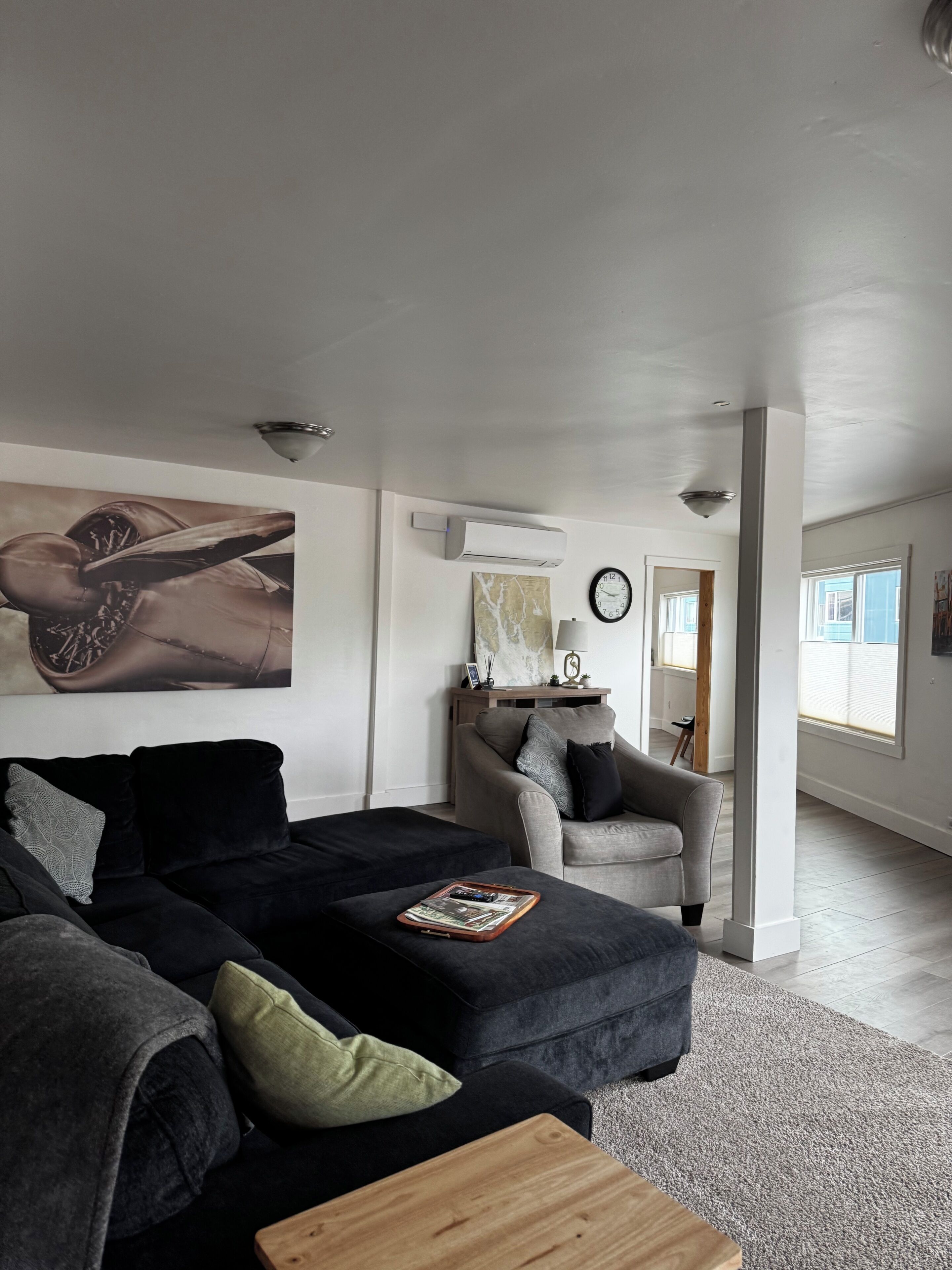 A modern living room with a sectional sofa, a coffee table, and a dining area with a chair and table.