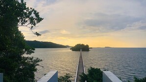 A long pier extending into a calm body of water, surrounded by lush greenery and hills in the background. - Villa between sea and mountain with beautiful places, live the adventure and romance. (Monte Rojo)