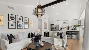 A modern living room with a sofa, coffee table, and artwork on the wall.
