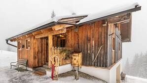 A rustic wooden cabin with a sloped roof, a wooden porch, and a bench. - Heregger Hütte by Interhome (Dellach)