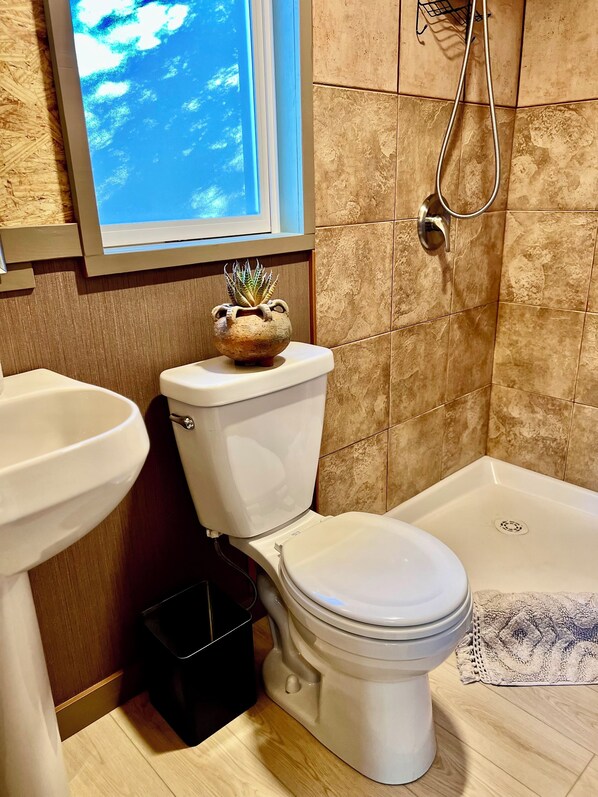 Un baño con inodoro, lavabo y ducha.