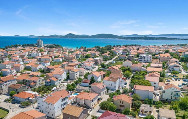 A coastal residential area with houses, a clear view of the sea, and a distant mountain range. - Amazing apartment in Vodice with WiFi (Vodice)