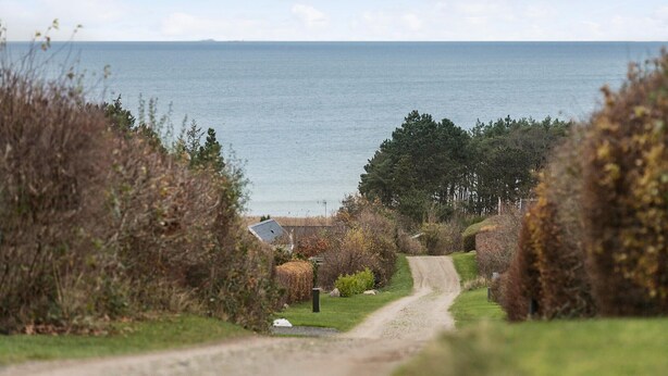 Une route côtière menant à une maison avec vue sur la mer.