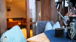 A cozy room with a wooden table, a plush blue chair, and a black vase with a white design. - Alberts Huamat by Interhome (Fliess/Landeck/Tirol West)