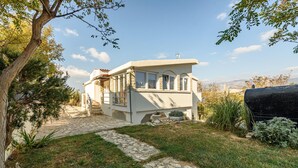A two-story house with a stone pathway leading to the entrance, surrounded by greenery and a clear sky. - Amazing apartment in Pag with house sea view (Pag)