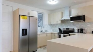 A modern kitchen with stainless steel appliances, a microwave, and a large island. - 2-bedrooms condo with spectacular Ocean View, WiFi, AC in delightful Montego Bay (Montego Bay)