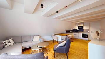 A modern apartment with a living area, kitchen, and dining space.