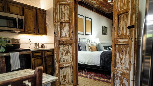 A rustic kitchen with wooden cabinets and a microwave. - Cozy studio with queen pullout sofa on scenic working ranch in Fort Worth. (Fort Worth)