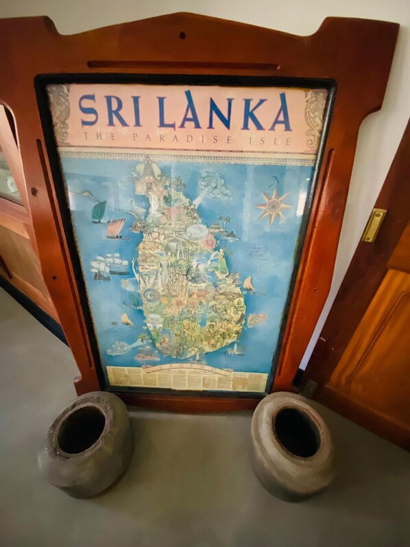 A framed map of Sri Lanka titled 'The Paradise is Here' with a wooden frame and two clay pots at the base. - Happy Valley Residence Unawatuna (Unawatuna)