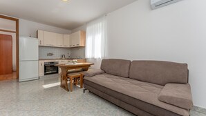 A modern kitchen with a dining area, a sofa, and a tiled floor. - Gorgeous apartment in Sveti Filip i Jakov (Sveti Filip i Jakov)