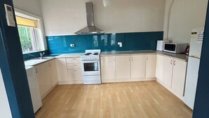 A compact kitchen with a stove, oven, microwave, and cabinets. - An ultra-convenient 2 bed 2 bath unit near CBD with River Derwent&mountain views (Sandy Bay)