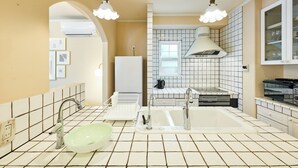 Una cocina moderna con un lavamanos grande, salpicadero de azulejos blancos y un horno empotrado.