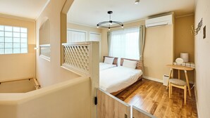 Un dormitorio con cama de madera, una mesita y una silla.