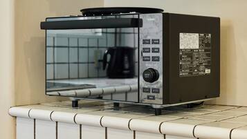 A kitchen with a built-in toaster oven on a tiled countertop.