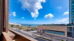 A modern building with large windows and a view of the sea.