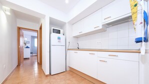 A modern kitchen with white cabinets, a built-in oven, and a microwave.