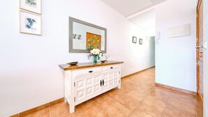 A hallway with a white console table, a mirror, and framed artwork on the walls.