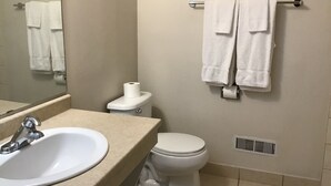 A bathroom with a sink, toilet, and towel rack.