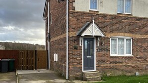 A two-story brick house with a dark front door, white window shutters, and a small porch. - Tranquil Sheffield Retreat - 3 Bedroom House (Sheffield)