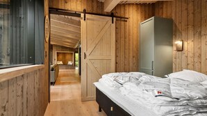 Een slaapkamer met een bed, een kledingkast en een schuifdeur naar een badkamer.