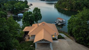A house with a dock extending into a lake, surrounded by trees. - 900ft of water frontage: Private Spacious Luxury Waterfront Point @ Smith Lake! (Bremen)