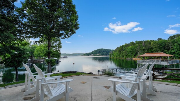 A lakeside view with Adirondack chairs and a covered seating area. - 900ft of water frontage: Private Spacious Luxury Waterfront Point @ Smith Lake! (Bremen)