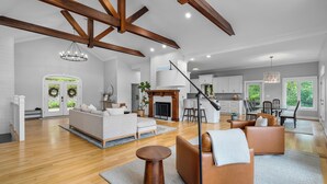 A spacious living room with a fireplace, a dining area, and a kitchen in the background. - 900ft of water frontage: Private Spacious Luxury Waterfront Point @ Smith Lake! (Bremen)