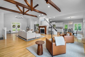 A spacious living room with a fireplace, a dining area, and a kitchen in the background. - 900ft of water frontage: Private Spacious Luxury Waterfront Point @ Smith Lake! (Bremen)