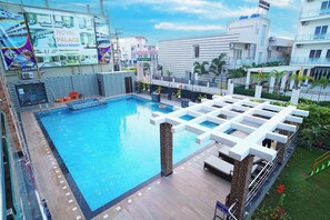 A swimming pool with a modern design, surrounded by a covered area with seating. - Royal Palace Beach Resort (Kanthi)
