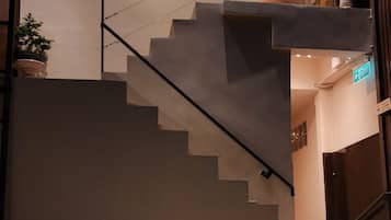 A modern indoor pool area with a staircase leading to an upper level.