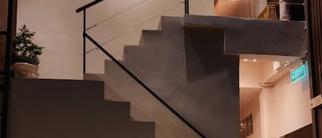 A modern indoor pool area with a staircase leading to an upper level.