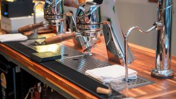 A coffee machine with a digital display, a wooden counter, and a metal drip tray.