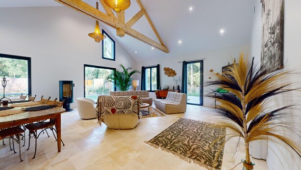 Un salón amplio con techo alto, ventanas grandes y chimenea.