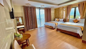 Une chambre d’hôtel avec deux lits, un bureau, une chaise et un téléviseur.