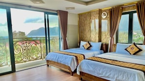 Une chambre d’hôtel avec deux lits, un balcon avec vue et une grande fenêtre avec des rideaux.