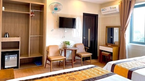 Une chambre d’hôtel équipée d’un lit, d’un bureau, d’une chaise, d’une télévision et d’une armoire.