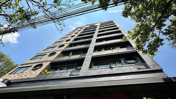 Un immeuble de grande hauteur, doté de nombreux étages, de grandes fenêtres et de balcons.