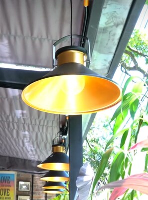 A hanging pendant lamp with a yellow shade and a black base, suspended from a metal structure. - LINVING 35 8TH FLOOR VIP (Medellín)
