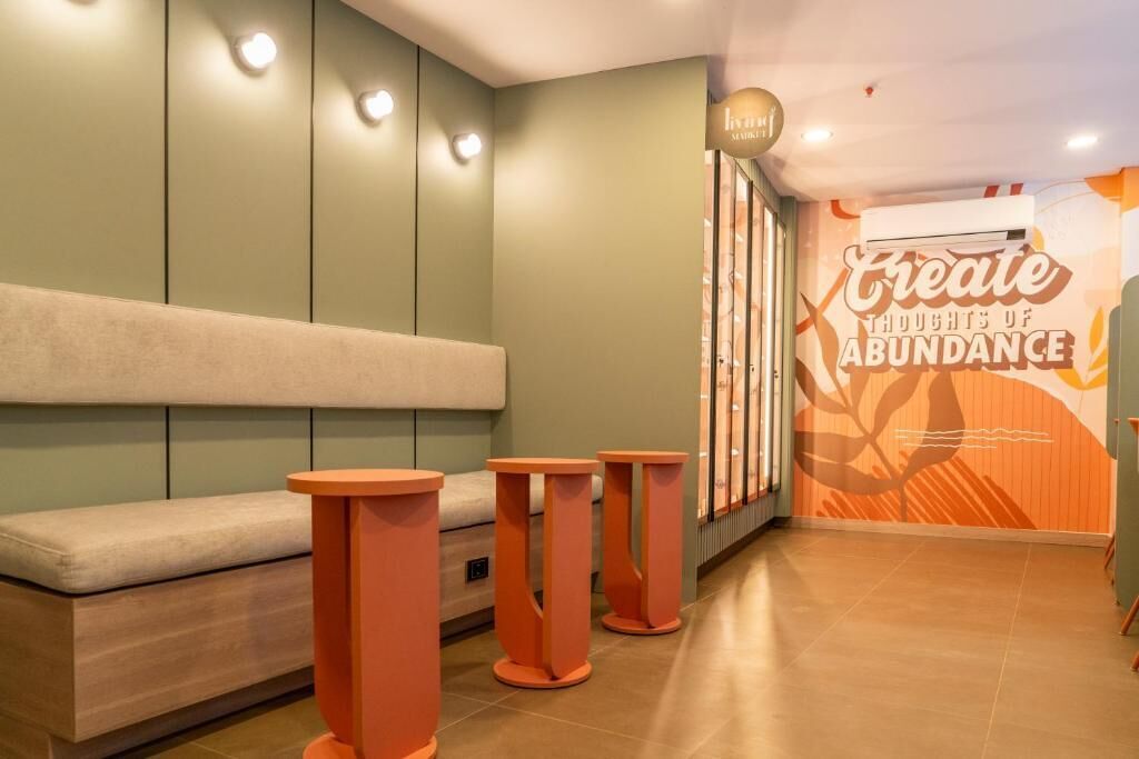 Un intérieur moderne comprenant un espace salon, un mur orné d’une citation inspirante et un système de climatisation original.