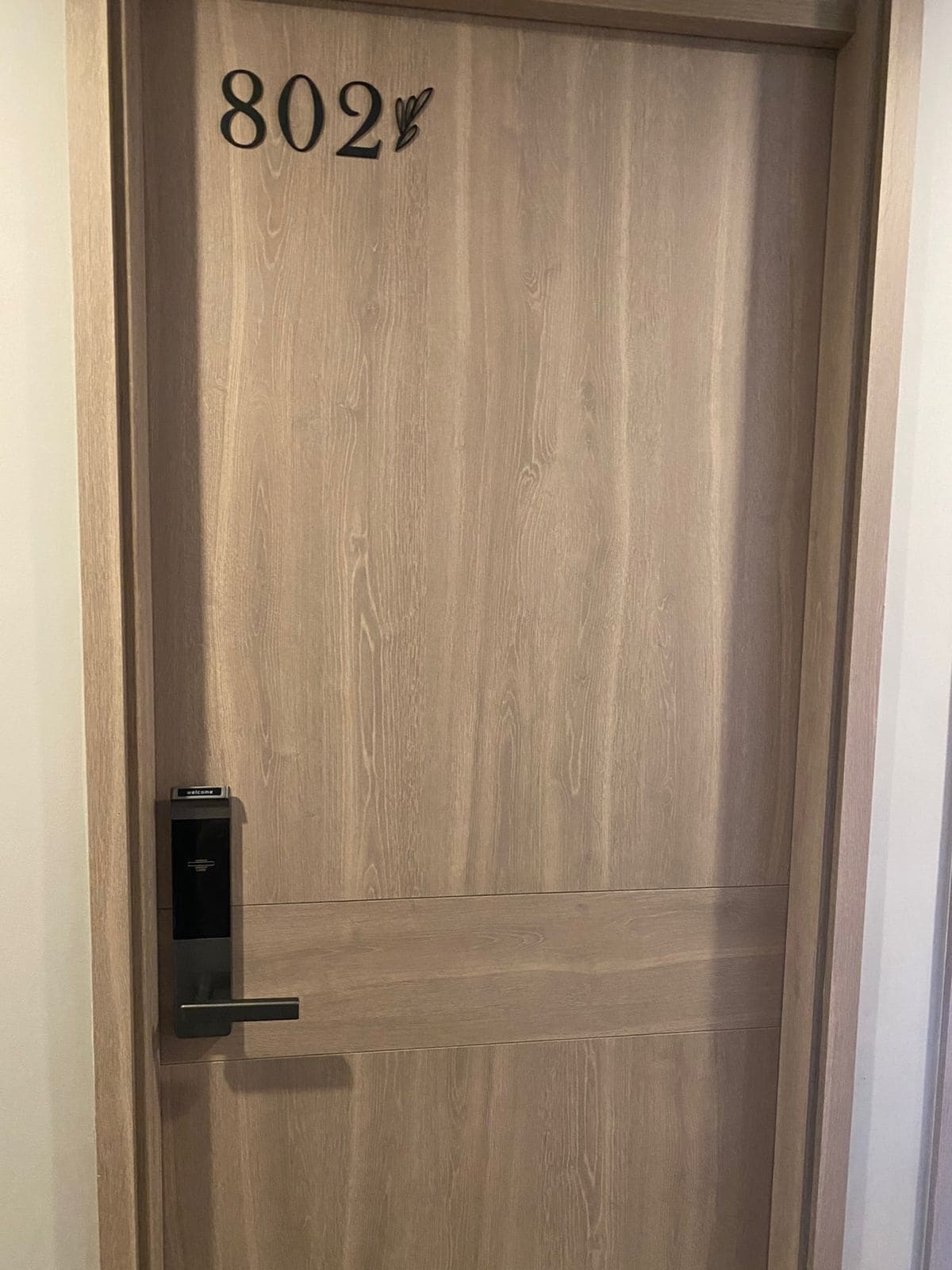 A wooden door with a number "802" and a doorbell.