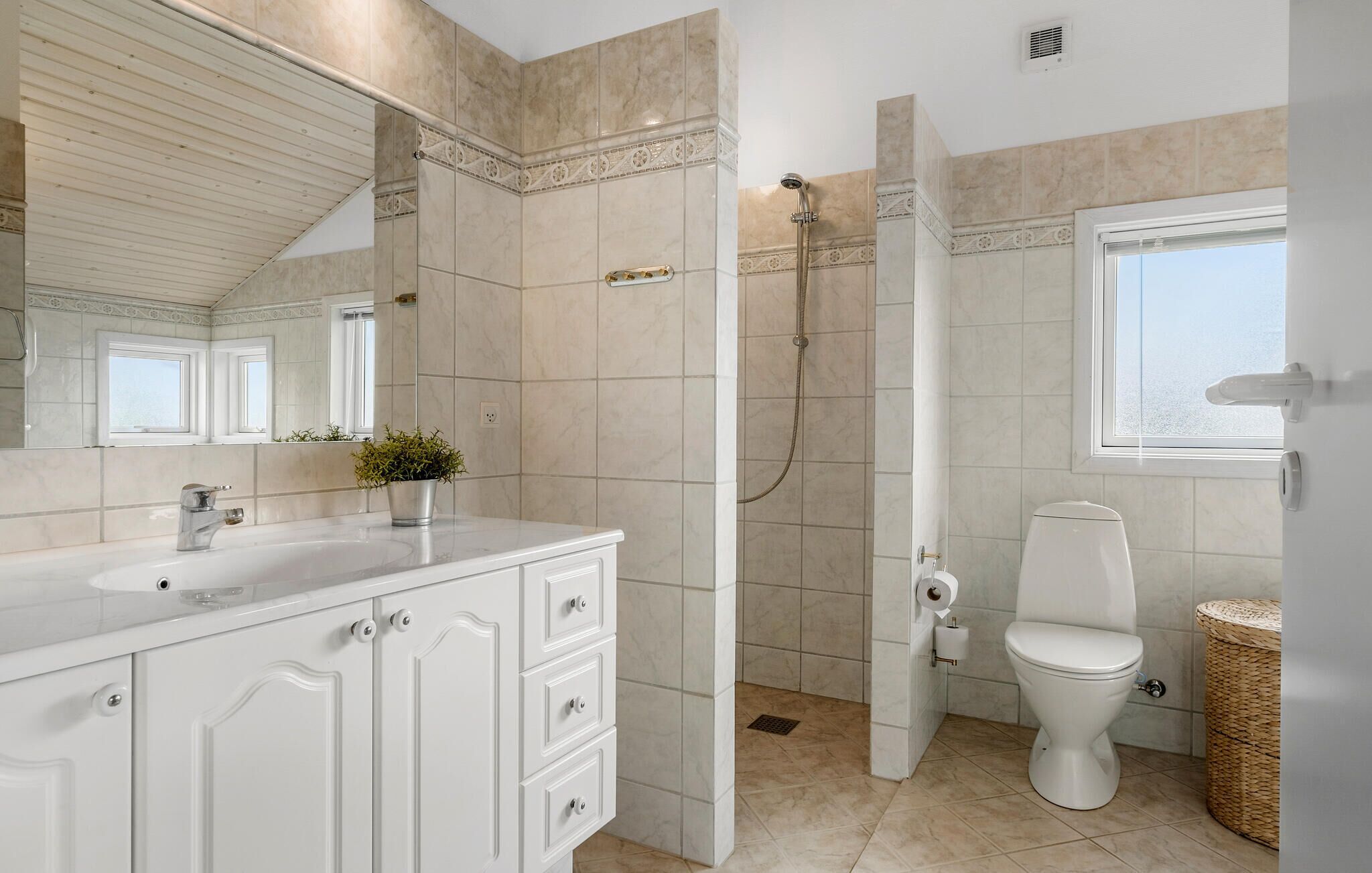 Un baño con ducha, inodoro, lavabo y mueble.