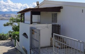 Situated near a body of water, this building offers a simple, functional design with a balcony and mountain views.