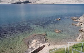 Enjoy a serene coastal view with a clear view of the water and sandy bottom.