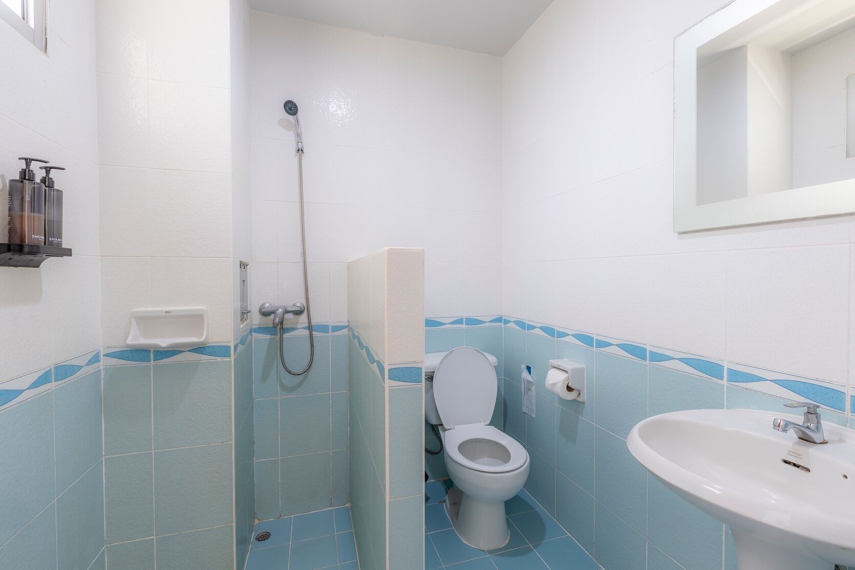 Un baño con ducha, inodoro y lavabo.
