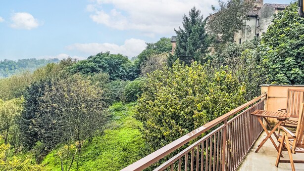 A balcony with a view of a lush green landscape and a historic building in the background. - Il Borghetto di Castagnole by Interhome (Castagnole Monferrato)