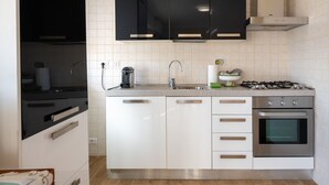 A modern kitchen with black cabinets, a stainless steel range, and a built-in oven. - Il Borghetto di Castagnole by Interhome (Castagnole Monferrato)