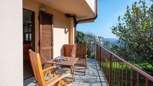 A balcony with wooden furniture and a view of the surrounding landscape. - Il Borghetto di Castagnole by Interhome (Castagnole Monferrato)