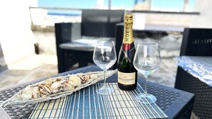 Una botella de champán Moët & Chandon sobre una mesa con dos copas y un plato de mariscos.