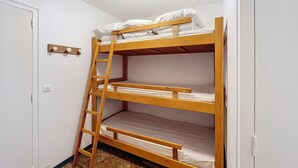 A bunk bed with a wooden ladder, white walls, and a ceiling light. - Hadès-appartement-4/5 pers- proche centre (Les Gets)