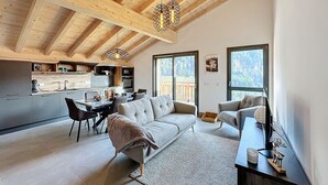 Un interior moderno con comedor, sofá y cocina con vigas de madera.